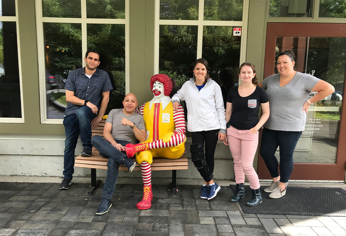 ronald-mcdonald-house employees posing with ronald mcdonald clown bench
